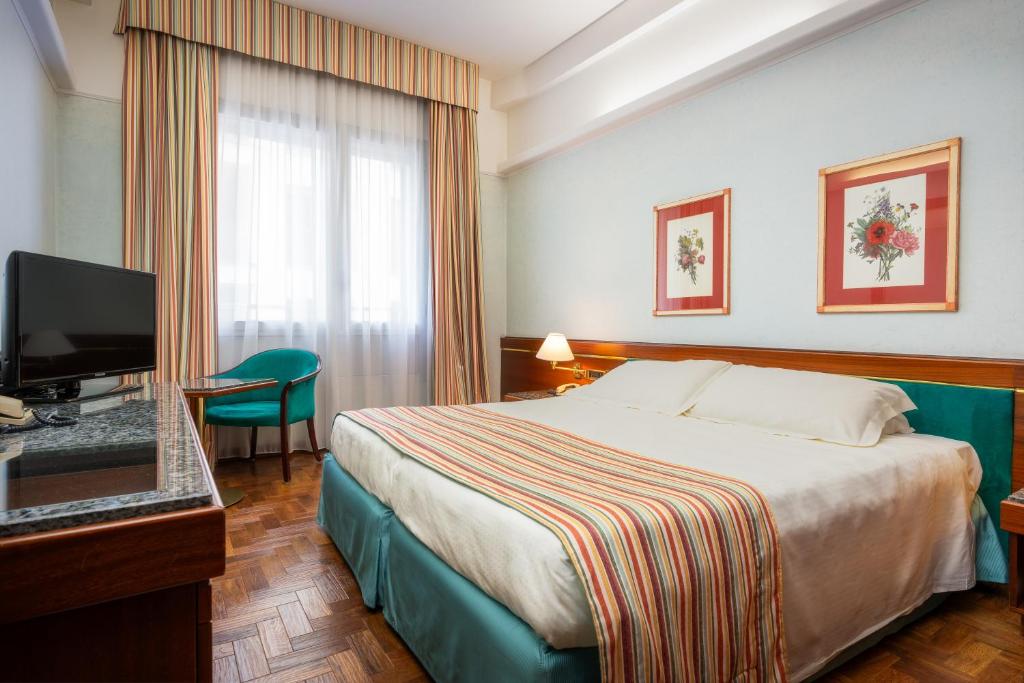 Habitación de hotel con cama y TV de pantalla plana. en Hotel Crivi's, en Milán