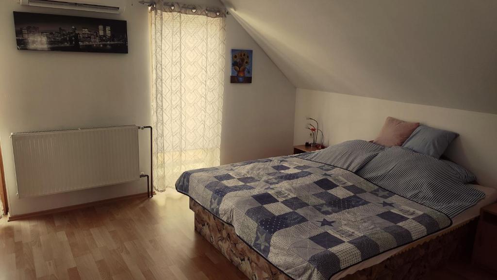 een slaapkamer met een bed met een geruite deken bij Norbi Vendégház in Balatonszárszó