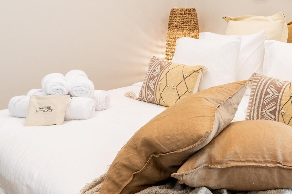 un letto bianco con asciugamani e cuscini sopra di Voyage Studio In Ansam With Golf Course View a Abu Dhabi