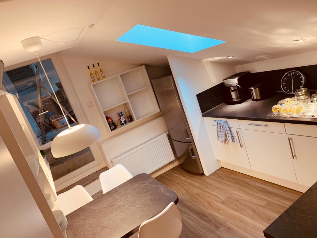 帕紹的住宿－FELIX LIVING 7, modern & cozy, geilste Dachterrasse der Stadt, 6 Schlafzimmer，厨房配有桌子和蓝色的天花板灯