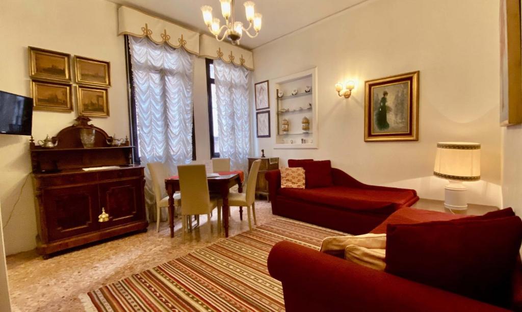 a living room with a red couch and a table at City Apartments San Marco in Venice