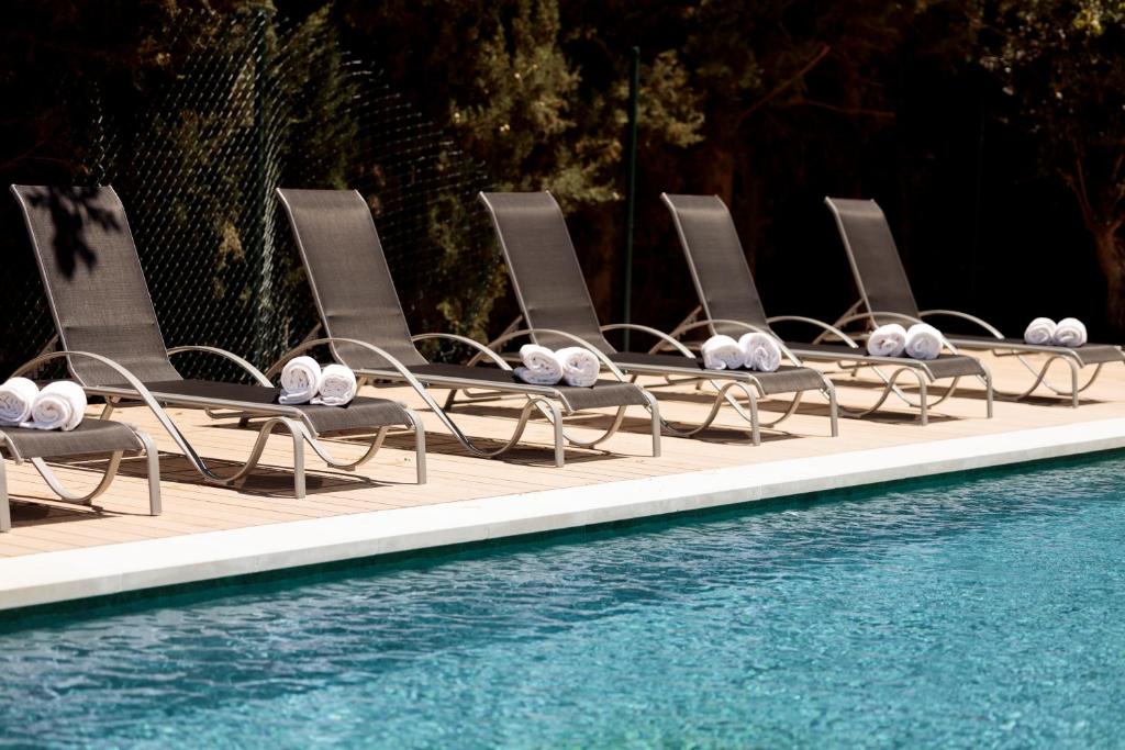 una fila de tumbonas junto a una piscina en Hotel Pax Guadalajara, en Guadalajara