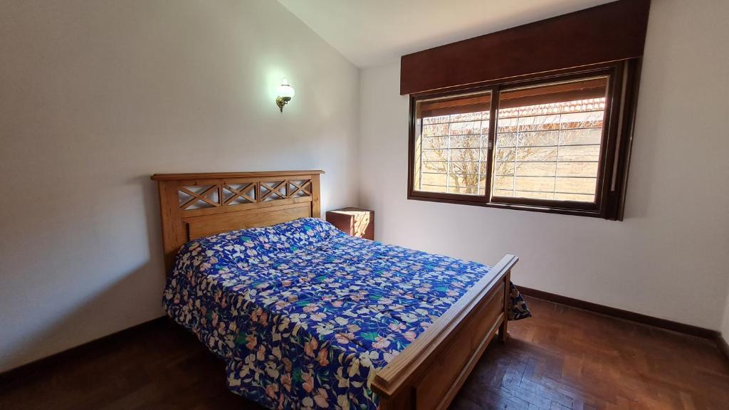 1 dormitorio con cama y ventana en Casa Rustica en Villa Carlos Paz