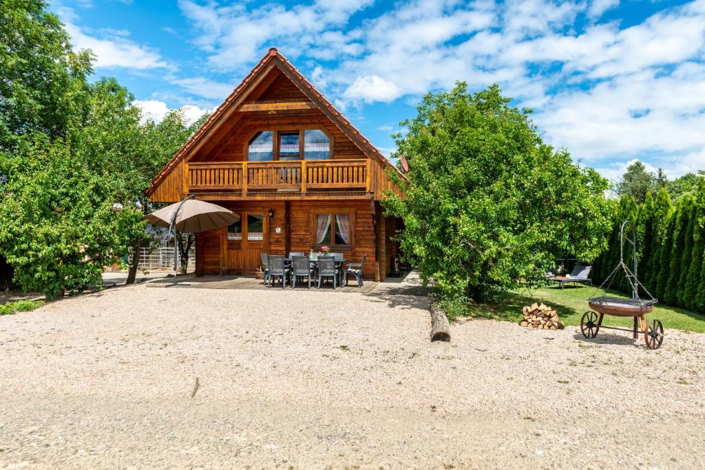 uma cabana de madeira com uma mesa e cadeiras à sua frente em Ferienblockhaus Glocker - Hof em Leibertingen