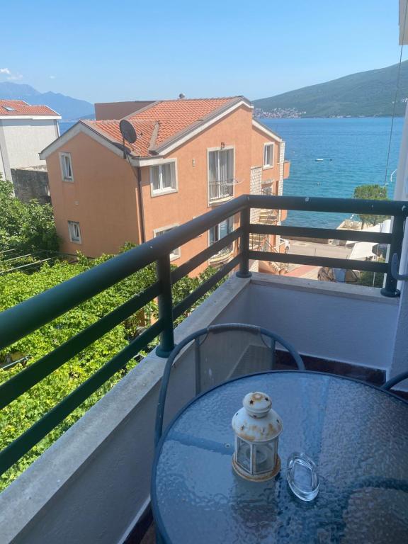 a table on a balcony with a view of the water at Beachfront two bedroom apartment Angelina in Ðenovići
