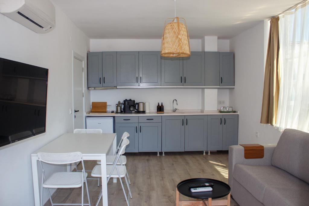 a kitchen and living room with blue cabinets and a table at Aloha Suites in Marmaris