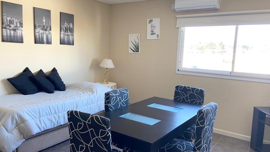 聖路易斯的住宿－BARCELONA APARTS，卧室配有一张床和一张桌子及椅子