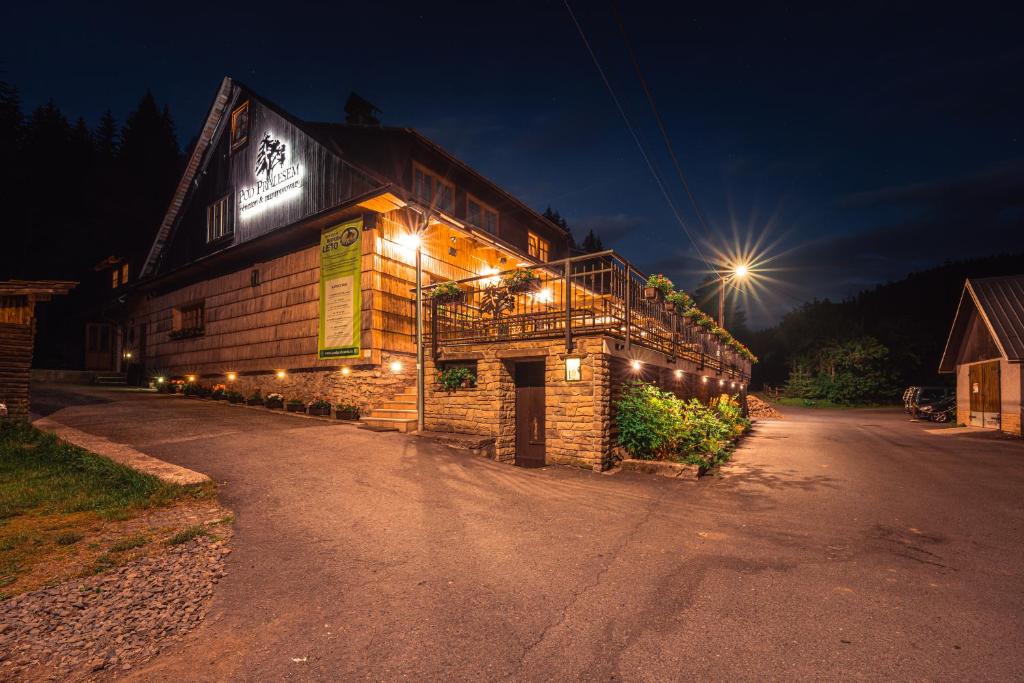 a building with lights on the side of it at night at Penzion pod Pralesem in Velké Karlovice