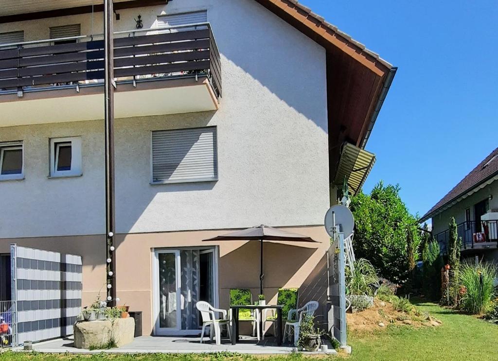 a house with a table and an umbrella in front of it at Ferienwohnung mit Garten in Ehrenkirchen