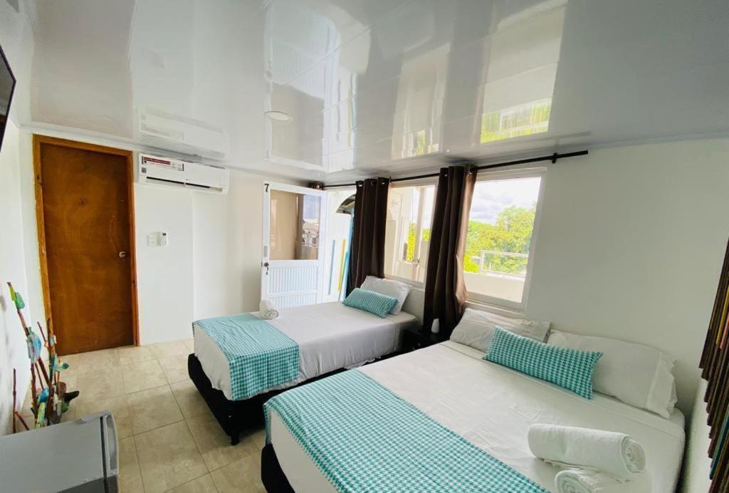 a bedroom with two beds and a window at Hostal islamar in San Andrés