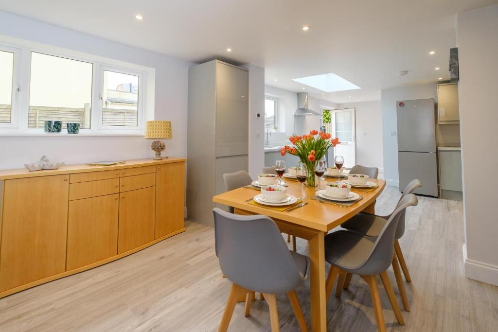 a kitchen and dining room with a wooden table and chairs at Primrose Cottage in Leiston