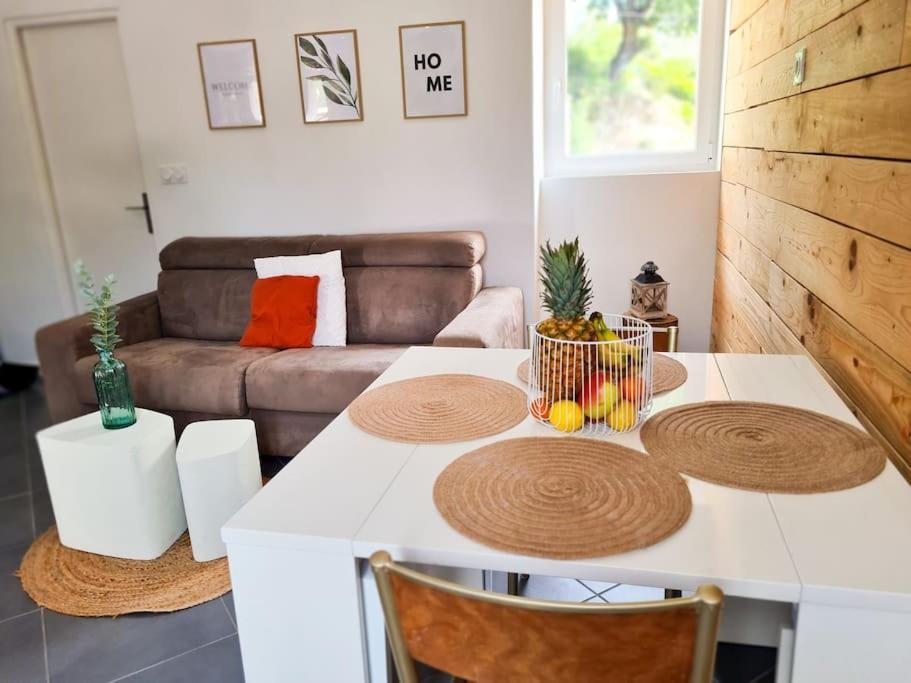 een woonkamer met een tafel en een bank bij Appartement avec terrasse proche Nice et Monaco in Contes