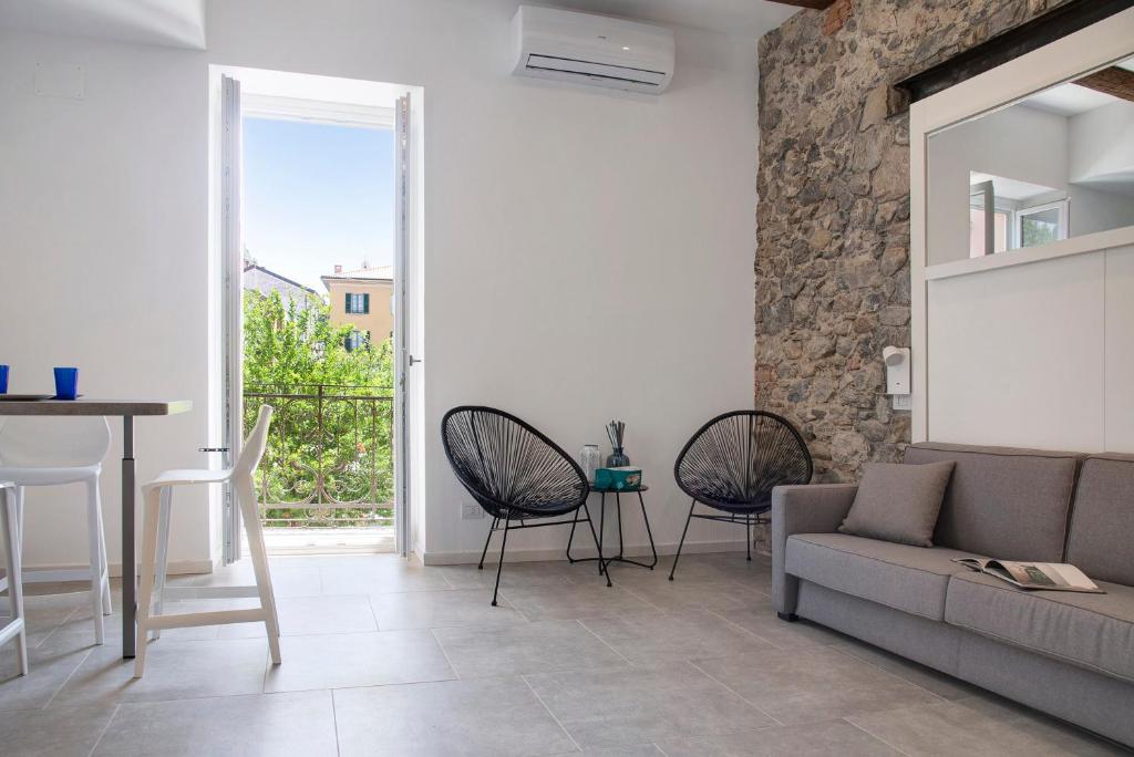 ein Wohnzimmer mit einem Sofa, einem Tisch und Stühlen in der Unterkunft Labiena 12 Lago maggiore in Laveno-Mombello