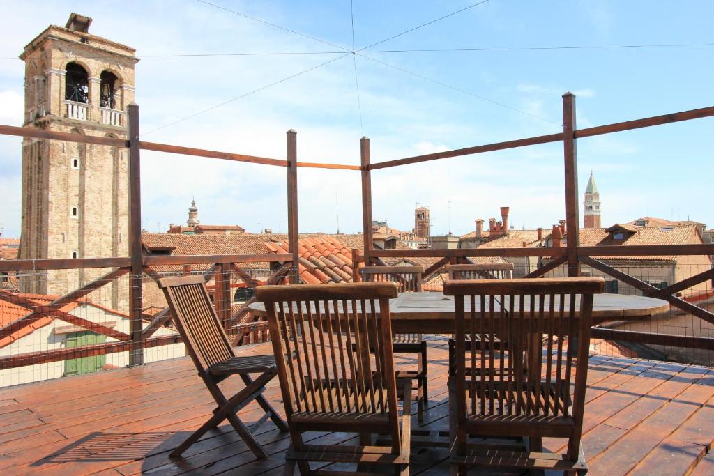 a table and chairs on a balcony with a clock tower at City Apartments Rialto Market in Venice