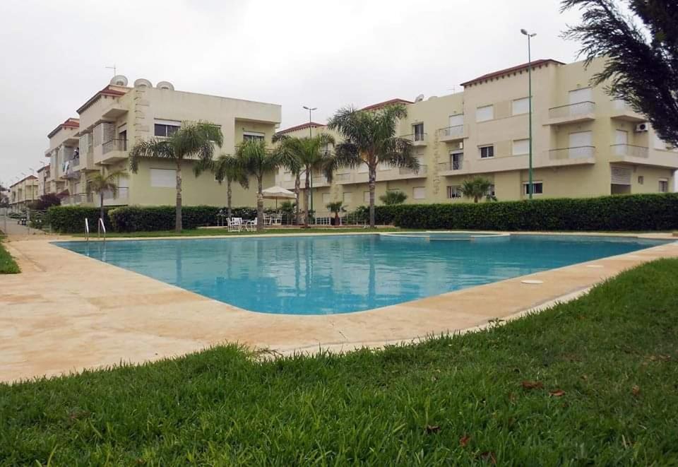 una piscina vuota di fronte a un edificio di Séjour avec piscine proche de la mer a Tamaris