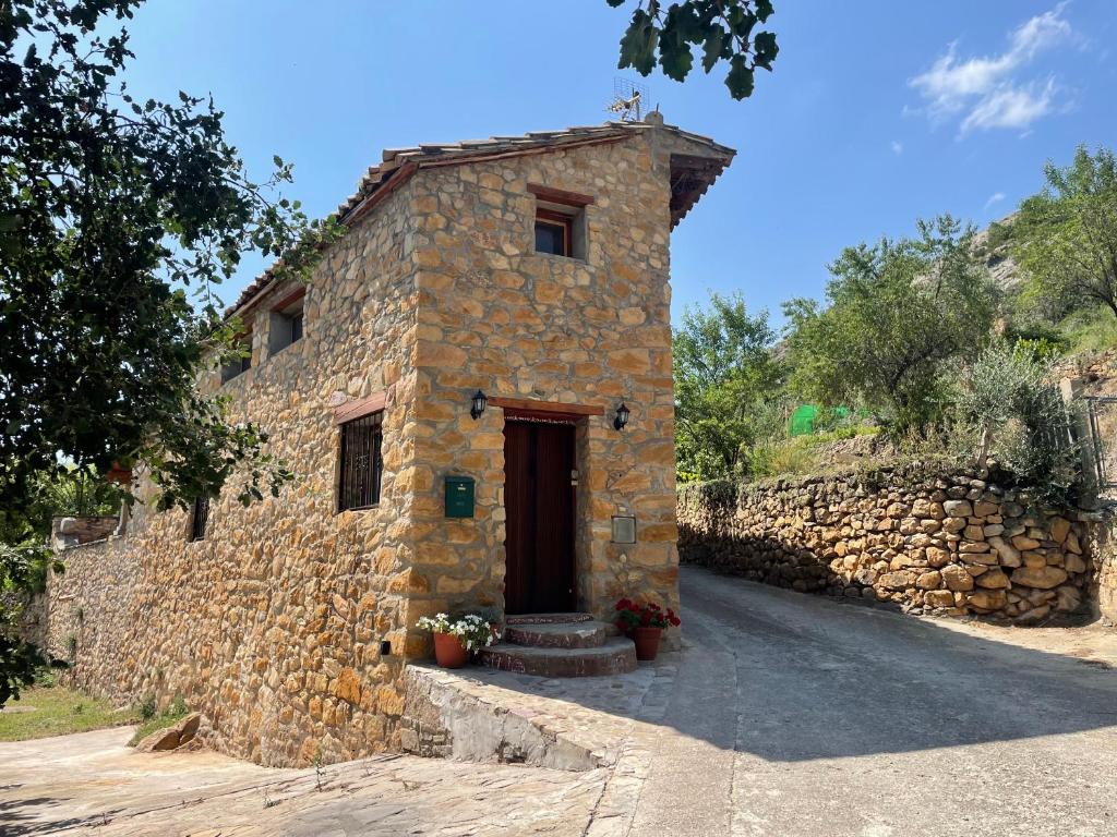 a stone building with a door on a road at Casa de Lilith in Aren