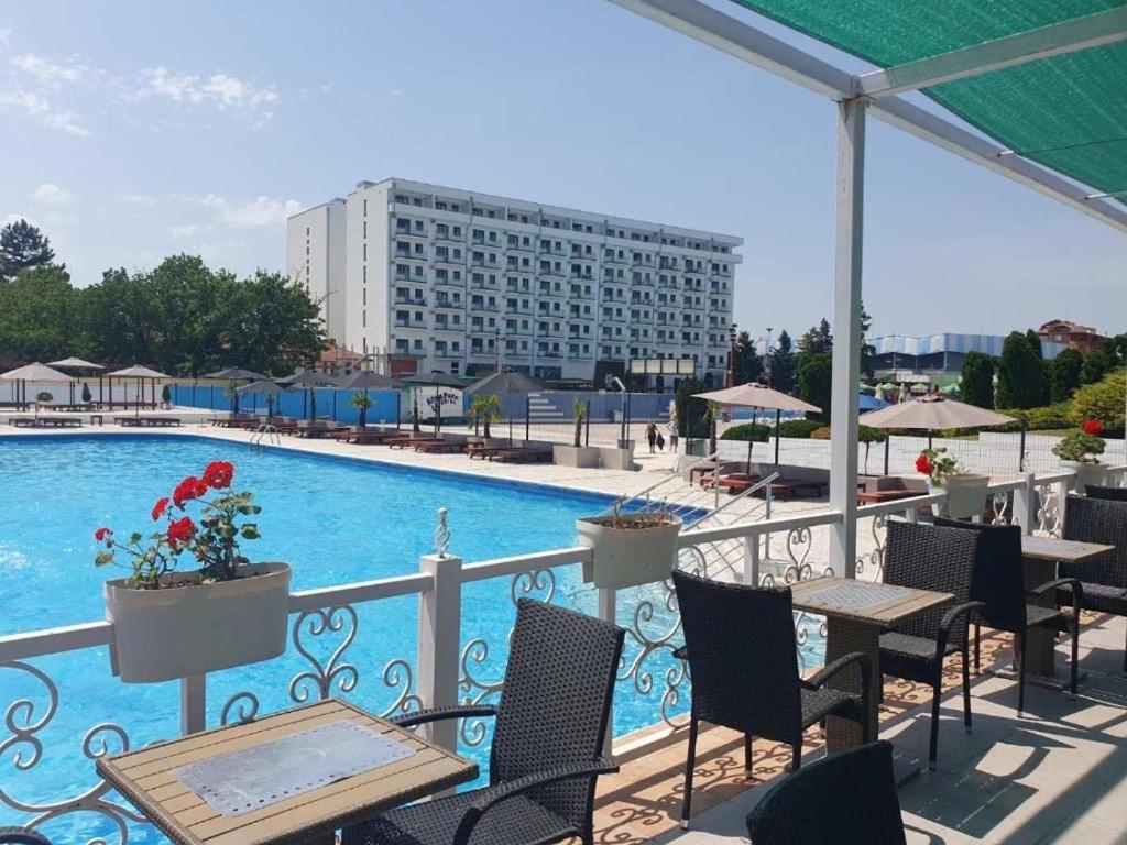 a balcony with tables and chairs and a swimming pool at De Lux Nedeljkovic in Jagodina