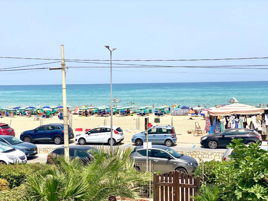 un parcheggio in spiaggia con auto parcheggiate di Casa Perla Marina sul mare a Castellammare del Golfo