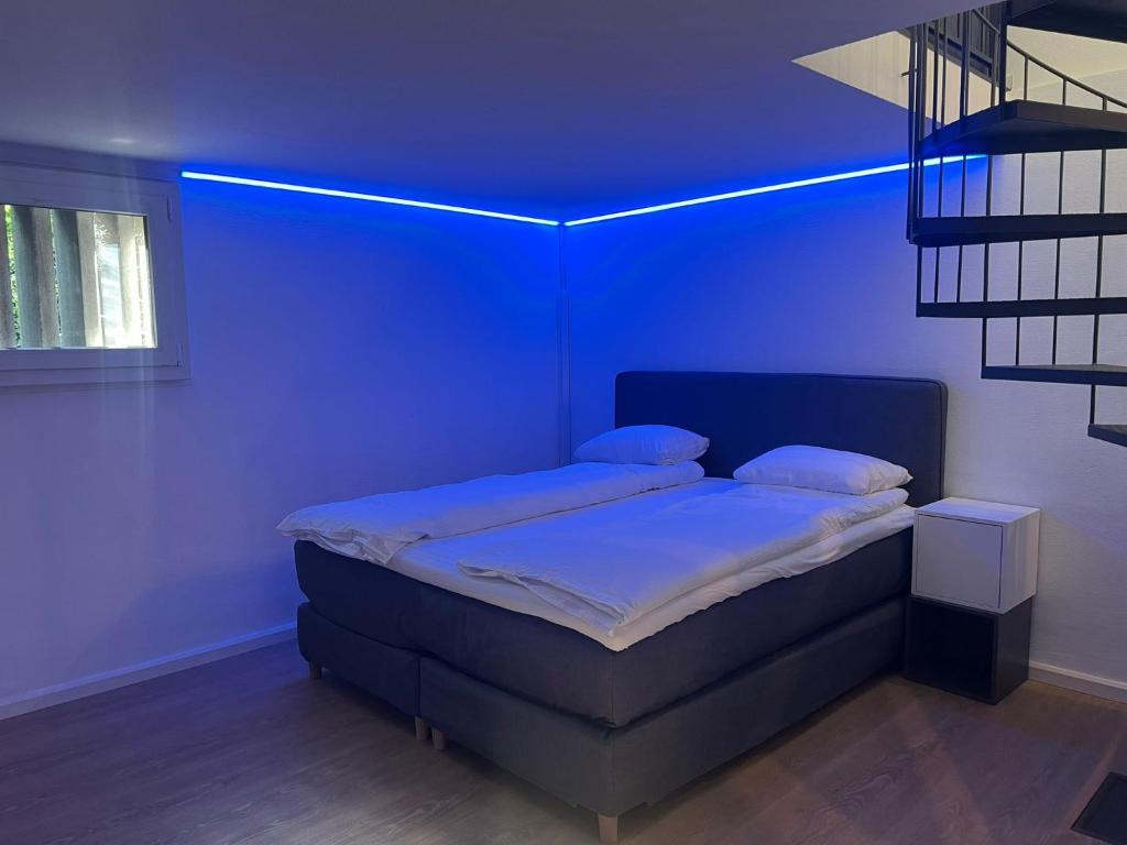 a blue room with a bed with a blue ceiling at House on historic city wall - Freihofapartments in Brugg