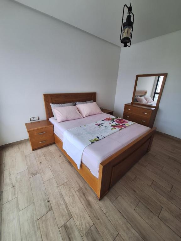 a bedroom with a large bed and a mirror at Apartment place italie in Rabat