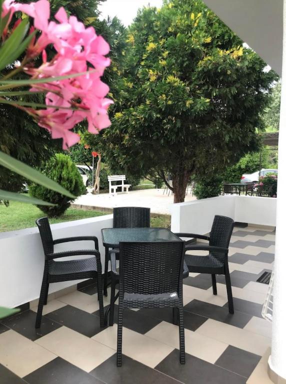a table and chairs on a patio with pink flowers at Casa Gazi in Ulcinj