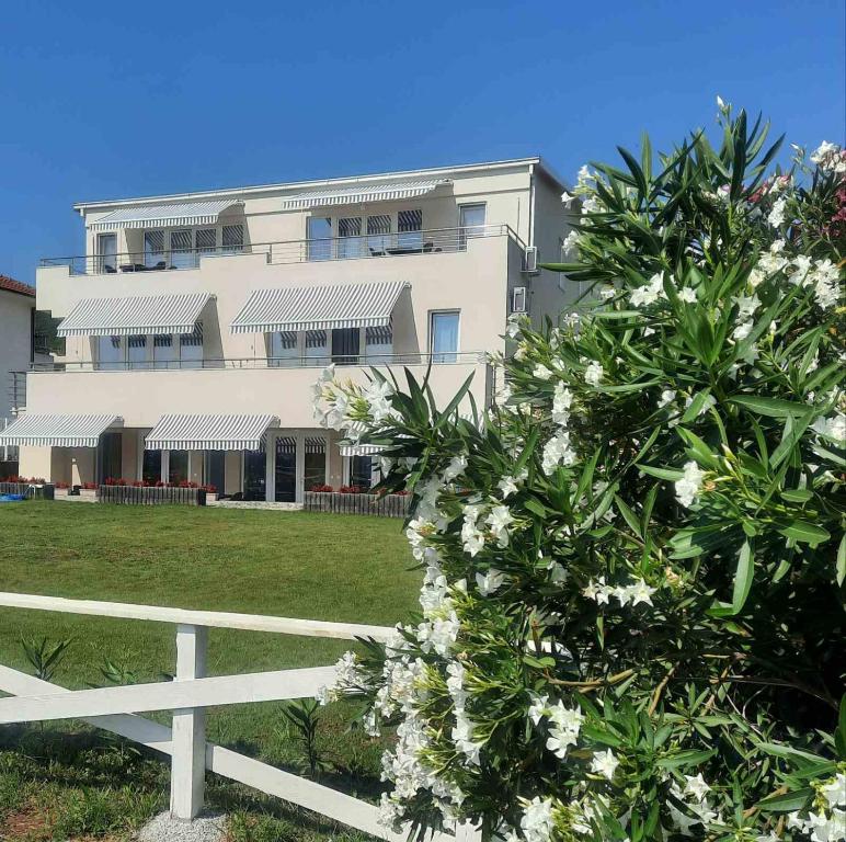 una cerca blanca frente a un edificio con flores blancas en B&B apartments en Star Dojran