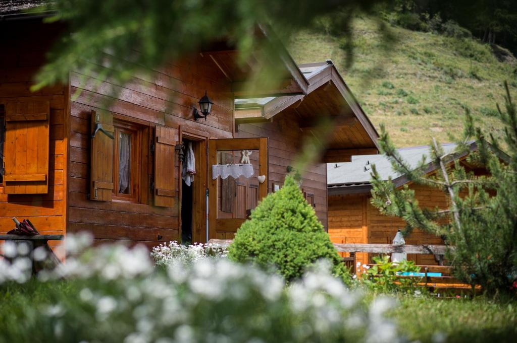 ein Holzhaus mit einer Tür im Hof in der Unterkunft Villaggio Gofree in Pragelato