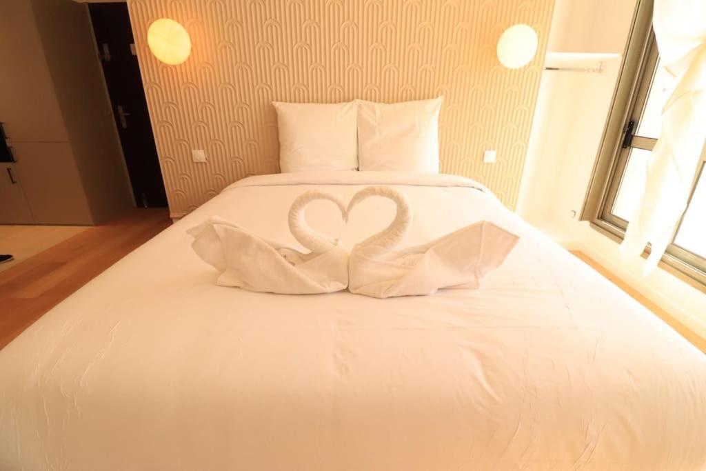 deux cygnes blancs sculptés dans un lit blanc dans l'établissement Studio 2pers#Nation#Grande Terrace#AC, à Paris