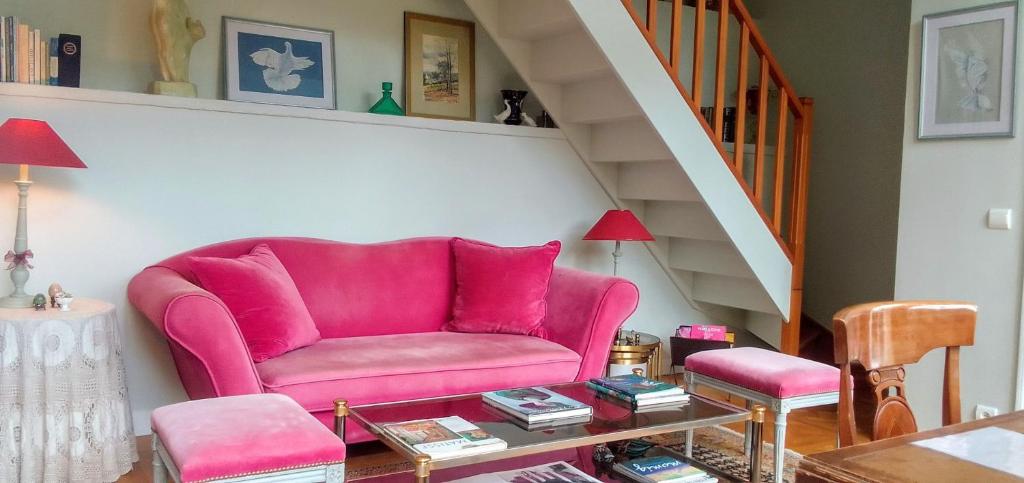 a pink couch in a living room with a staircase at L&#39;Orangerie White-Palacio in Versailles