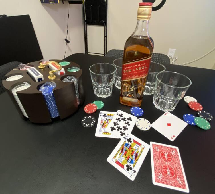 a table with a bottle of alcohol and playing cards at Cozy Bay Home Beach+Casino+More in Atlantic City