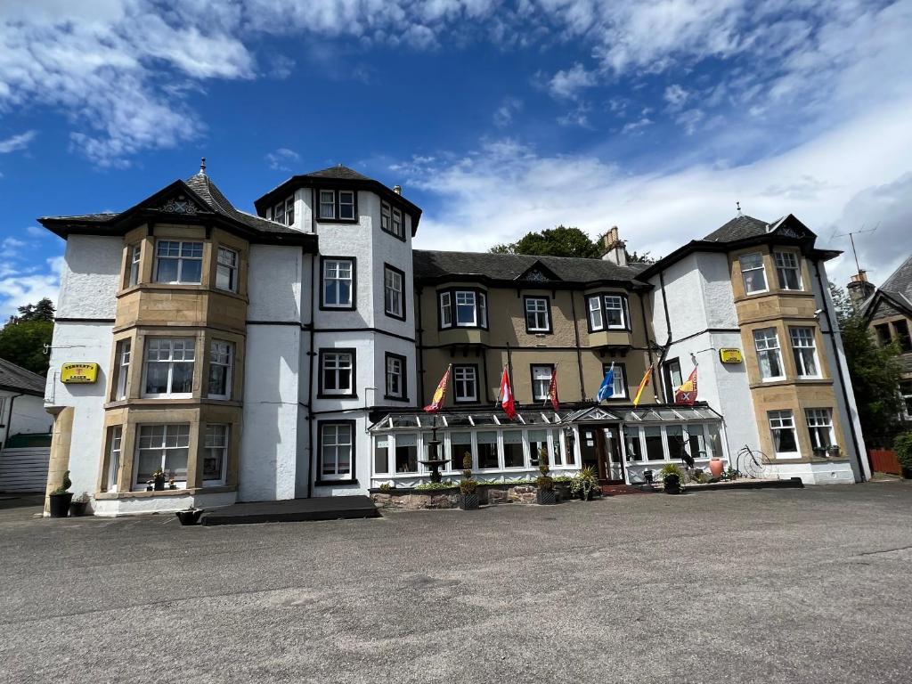 un gran edificio con banderas delante en Strathpeffer Hotel, en Strathpeffer