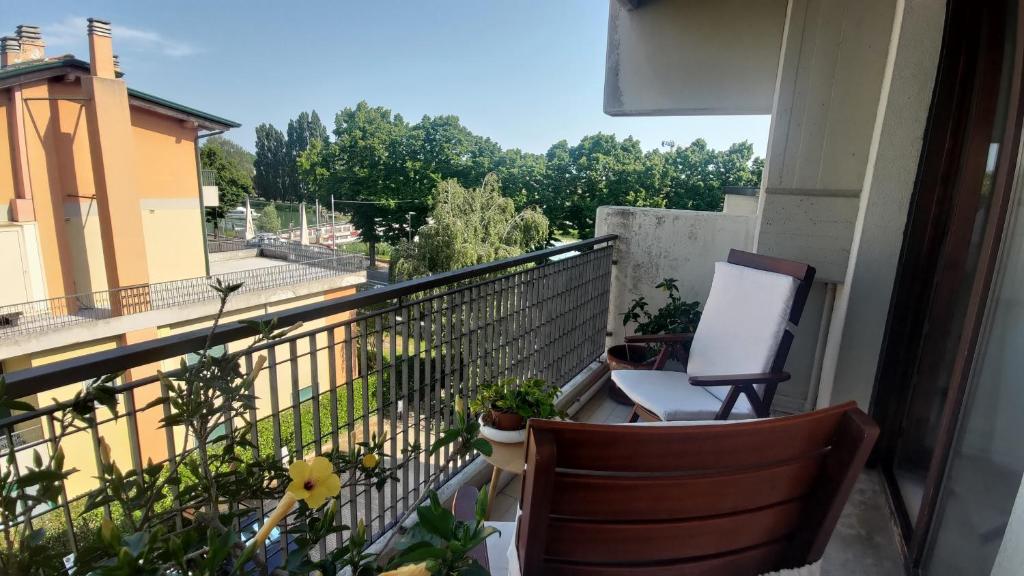 einen Balkon mit 2 Stühlen und Pflanzen in der Unterkunft Comodo per Venezia - Schissa apartment in Jesolo