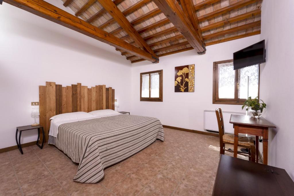 博沃倫塔的住宿－La Tenuta Va Oltre，一间卧室配有一张床、一张书桌和一台电视