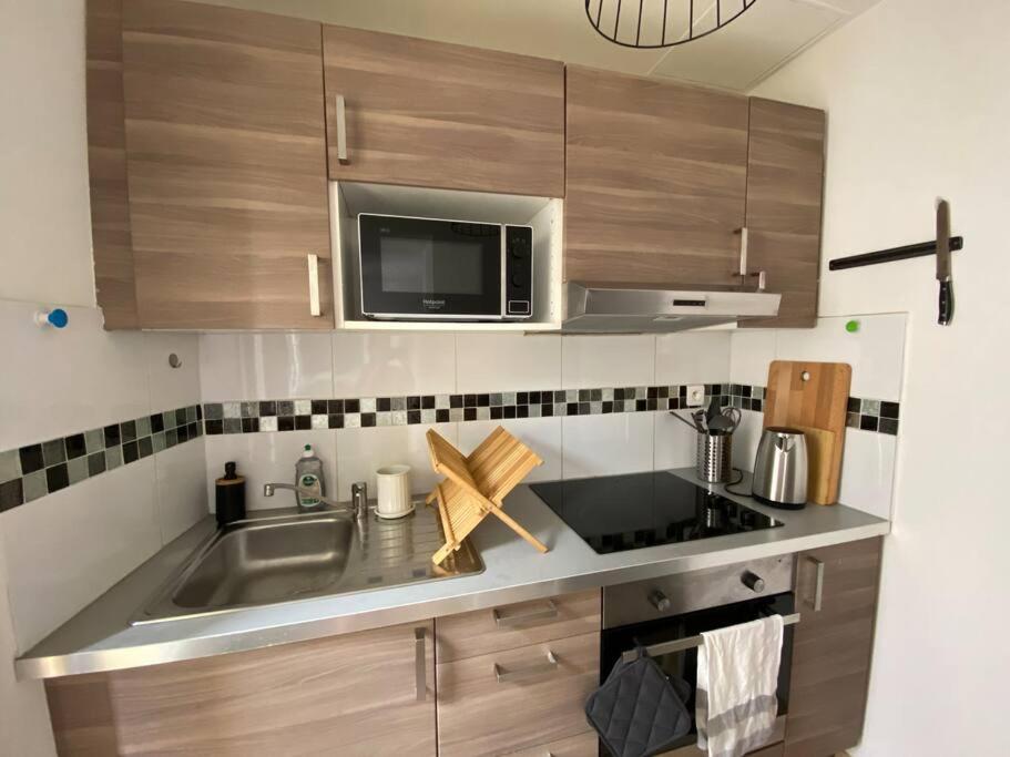 a kitchen with a sink and a microwave at Grand appartement jardins de la Fontaine in Nîmes