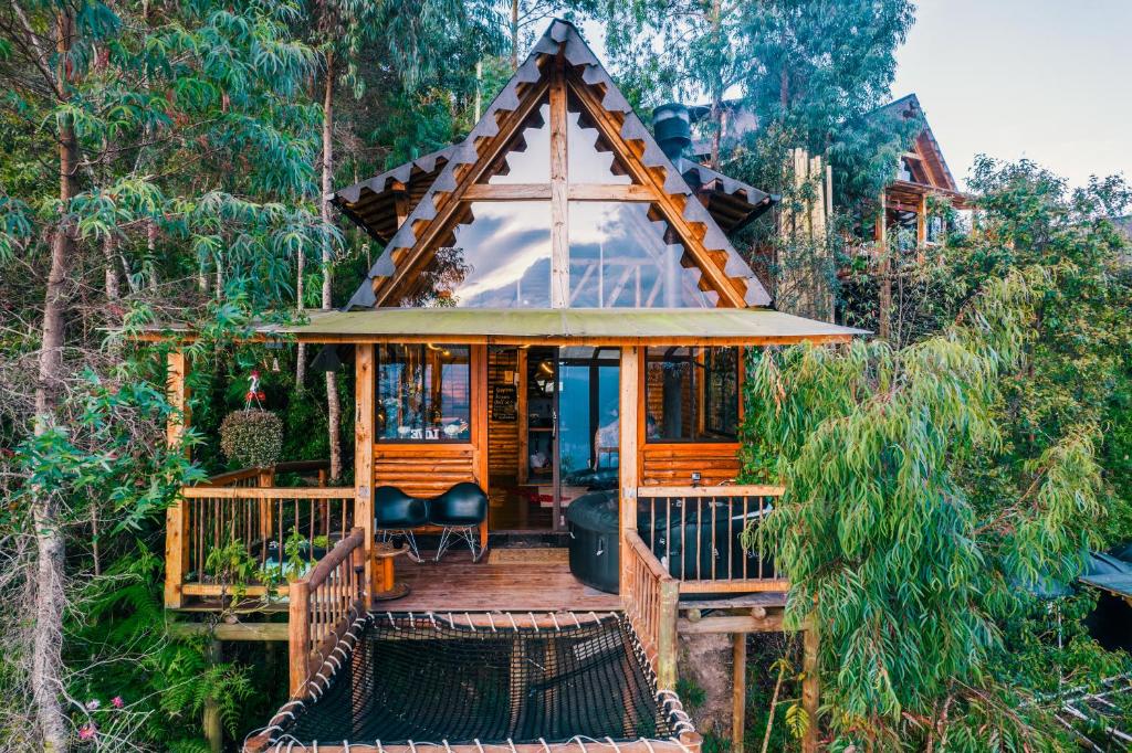 a cabin in the woods with a wrap around deck at Skyline Ecoliving Santa Elena in Santa Elena