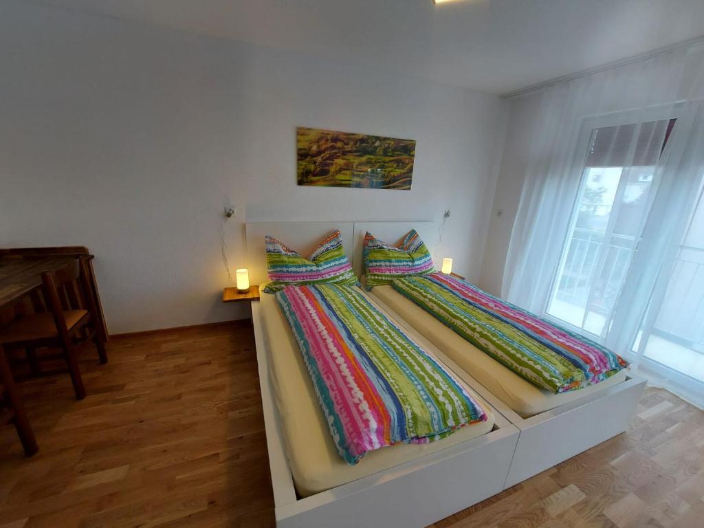 a bed with colorful sheets on it in a room at good bed Bettenhausen in Oberönz