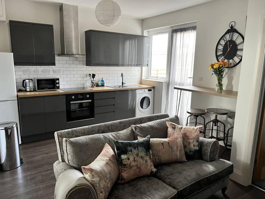 a living room with a couch and a kitchen at Ground floor flat in Keynsham
