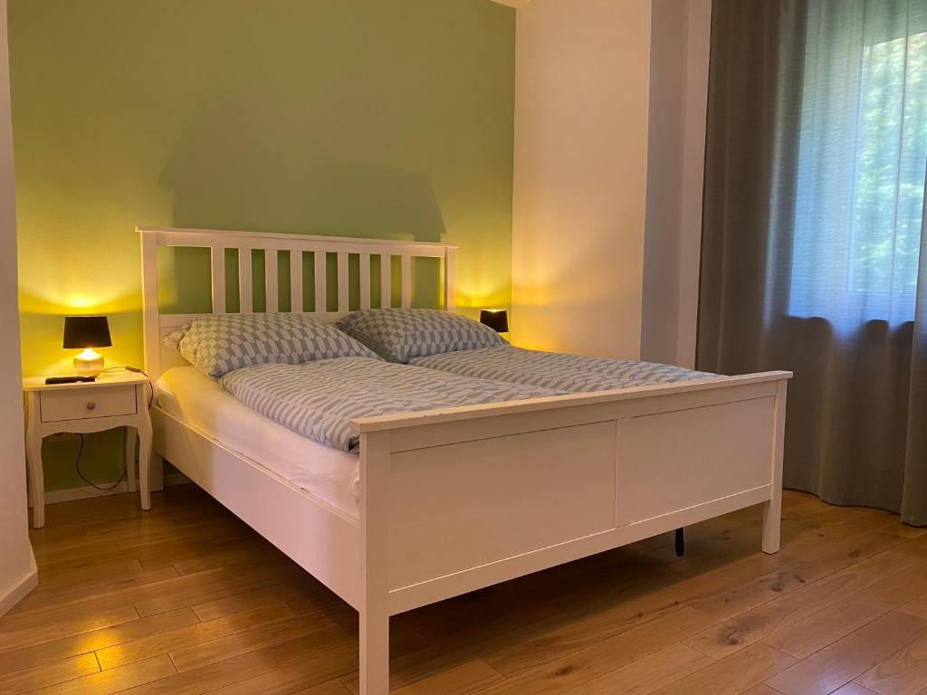 ein weißes Bett in einem Zimmer mit Fenster in der Unterkunft Fischbach Apartment in Saarbrücken