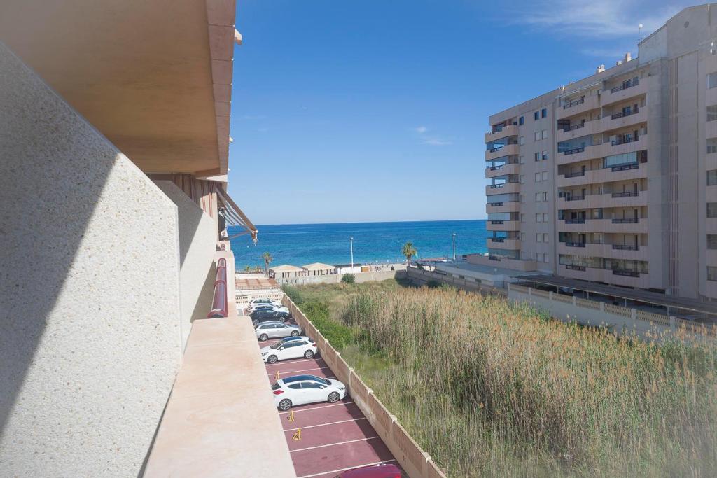 uma vista para a praia a partir de uma varanda de um edifício em Topacio 3 en prim43ra linea de la playa en Calpe con Buenas vistas em Calpe