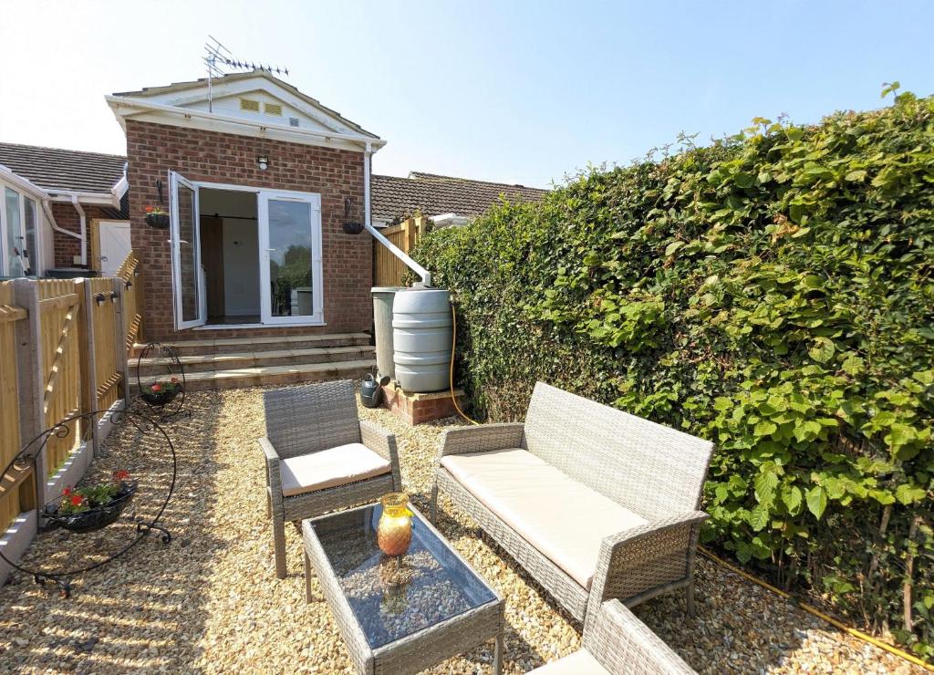 a patio with two chairs and a white couch at Little Dell in Newchurch