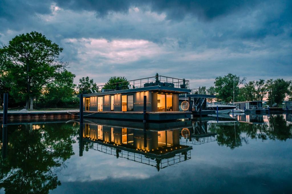 una casa flotante sentada en el agua por la noche en 200 qm schwimmendes Penthouse en Vieregge