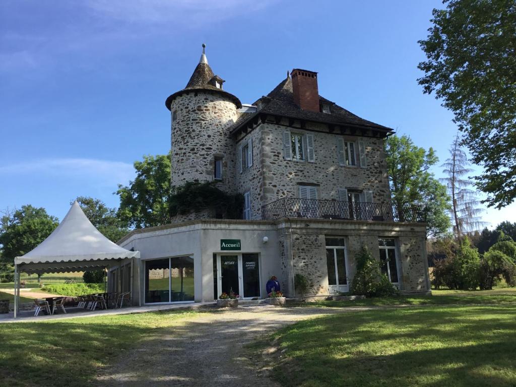 ein altes Gebäude mit einem Turm darüber in der Unterkunft La Chatelleraie in Saint-Étienne-de-Maurs