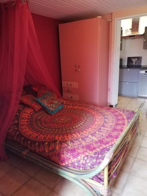 - une chambre dotée d'un lit avec un mur rouge dans l'établissement UN AVANT GOUT DU NIRVANA, à Canet