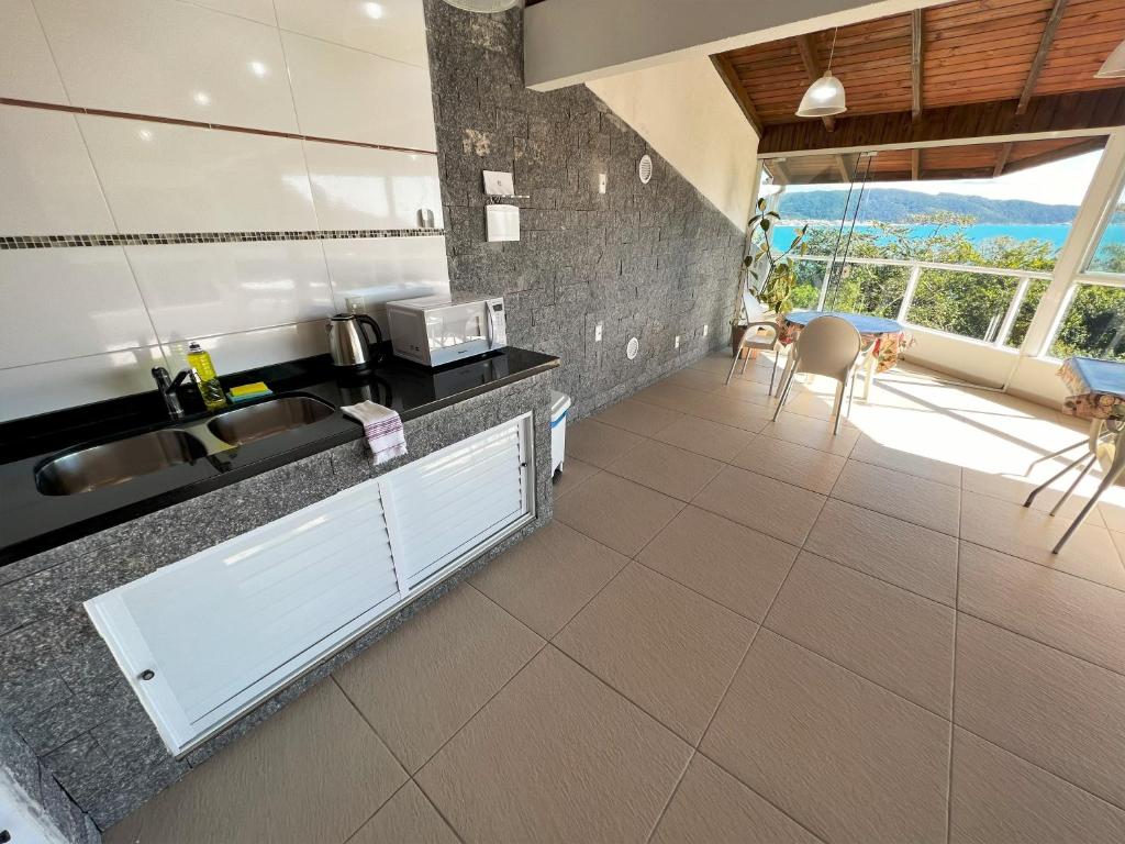 a kitchen with a sink and a counter top at Refúgio da Lagoinha - Centro de Bombinhas in Bombinhas