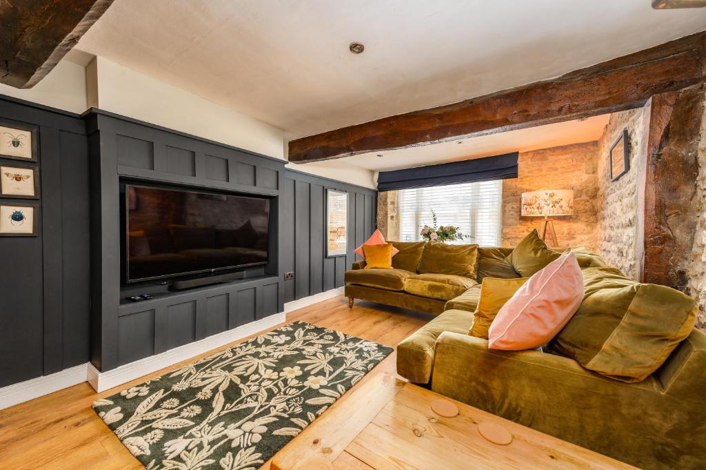a living room with a couch and a flat screen tv at Spacious, luxury town centre Granary conversion in Stamford