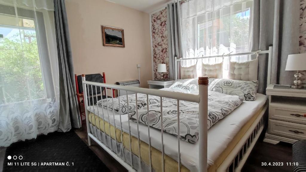 a bedroom with a crib in a room with a window at Penzion Pohoda - apartmány in Jeseník