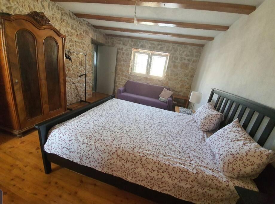 una camera con un letto e un divano viola di Villa anno 1911 a Šestanovac