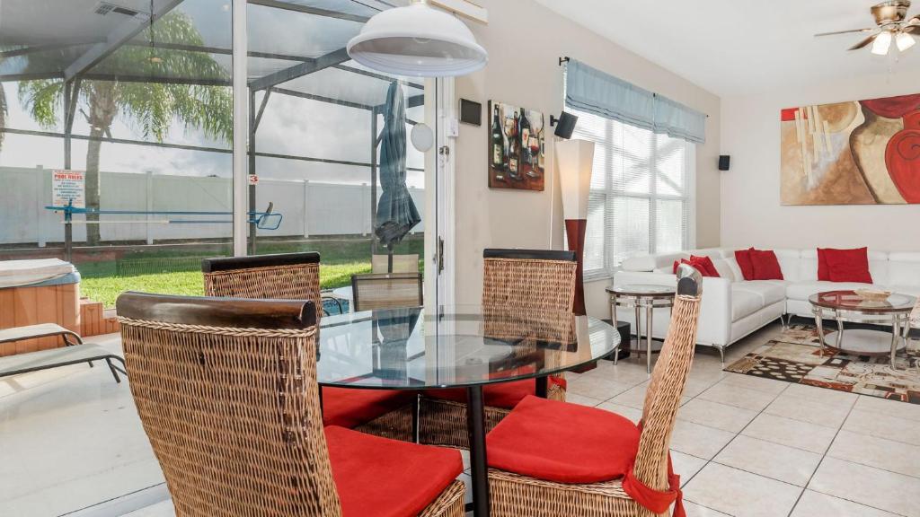 uma sala de jantar com uma mesa de vidro e cadeiras em 8008 King Palm em Kissimmee