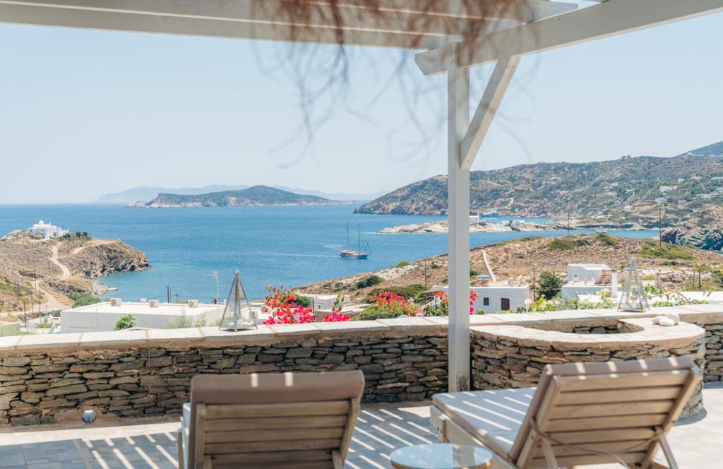 un patio con sillas y vistas al océano en Erifili Houses, en Faros