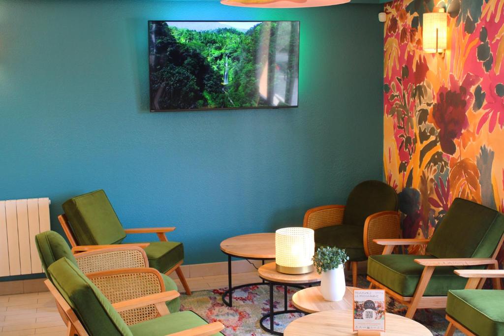 a waiting room with chairs and tables and a tv on the wall at KYRIAD HONFLEUR - La Riviere Saint Sauveur in Honfleur